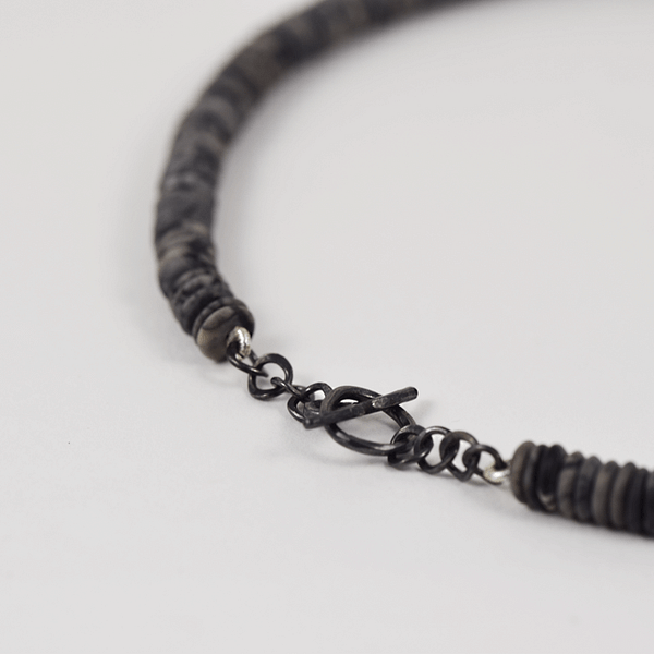 Detall de la tanca del collar de jaspes, or i plata oxidada
